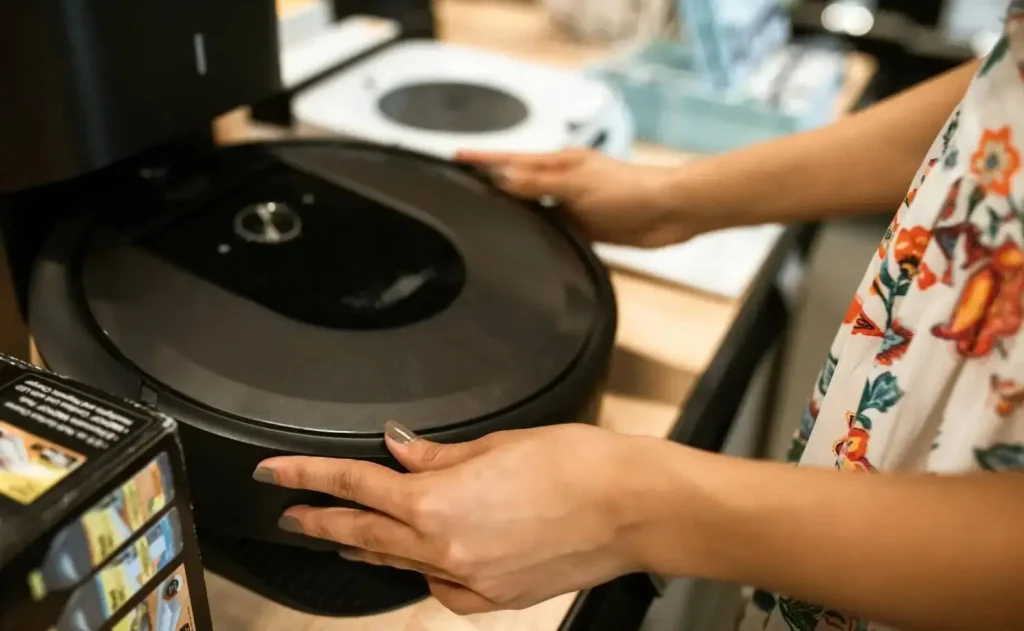 Can robots spy on you? Woman putting away her home robot vacuum 