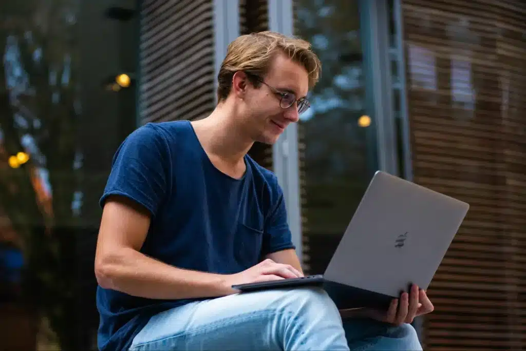 Should we be polite to AI and robots: Guy smiling at his laptop